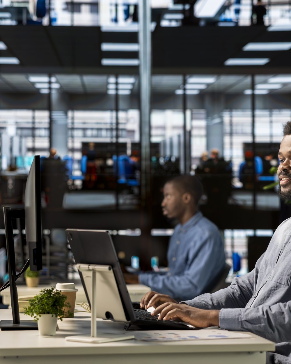 A Black professional working at his desk in a modern office